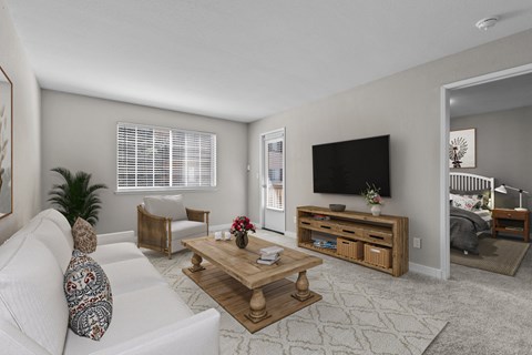 A living room with a white couch and a wooden coffee table.